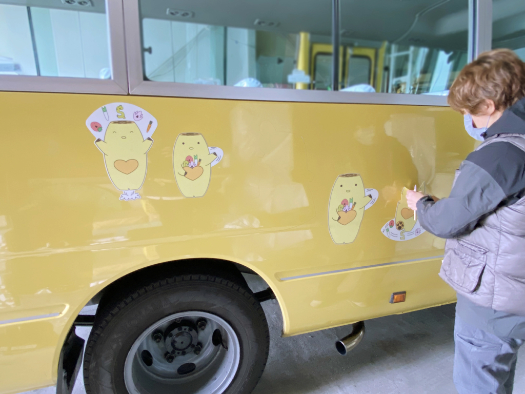 愛知県愛西市にある永和保育園のバスのカーサインの施工している様子。