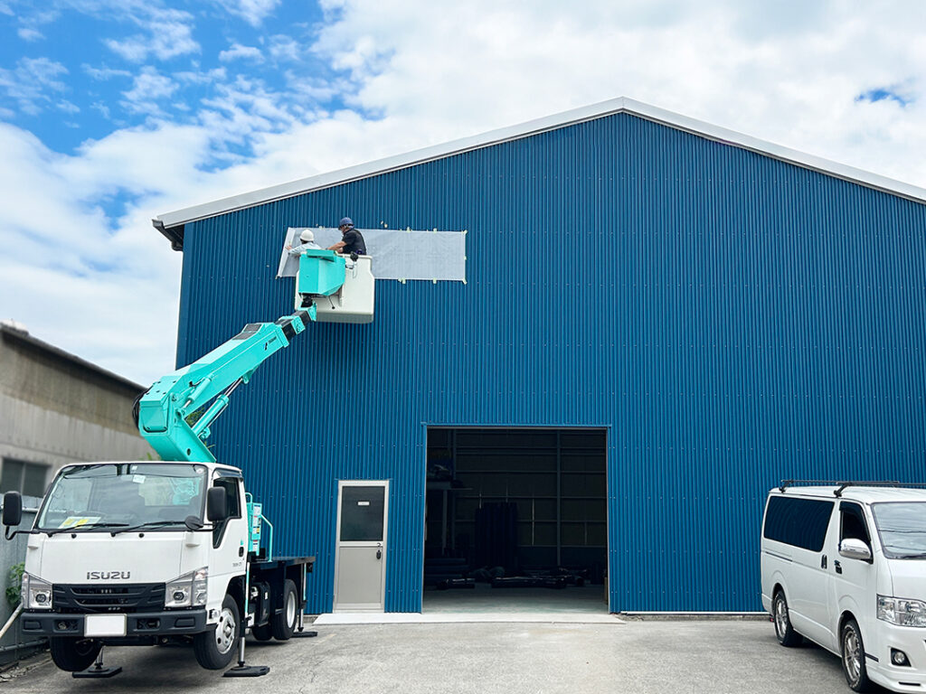 愛知県愛西市に本社を置くYS工業株式会社の施工中の写真です。看板を取り付ける位置の下穴を決めるため、型紙を貼っています。