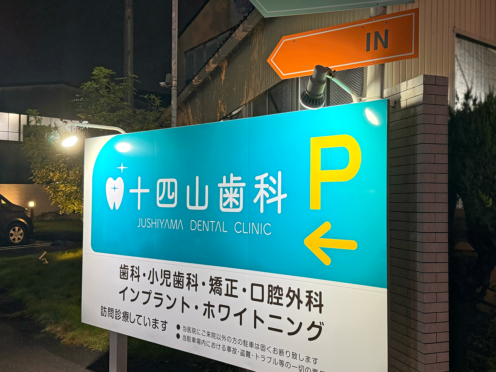 十四山歯科様の駐車場側の自立看板の夜間の写真です。