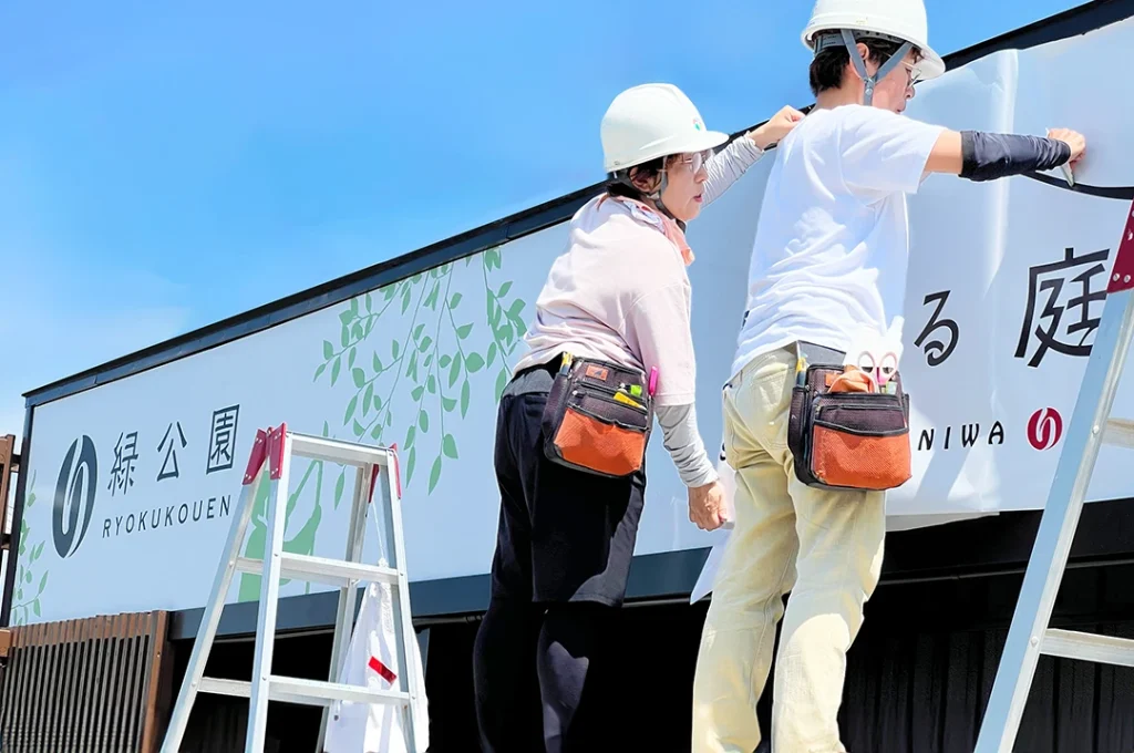 愛知県瀬戸市にある株式会社 緑公園 様の事務所に新たに看板を取り付けている施工中の写真です。