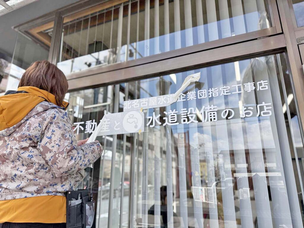 沖野不動産のガラスサインの施工中の写真です。