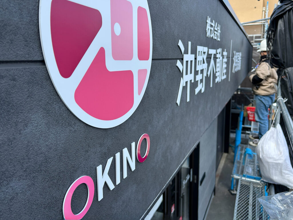 沖野不動産のファサードサインの施工中の写真です。