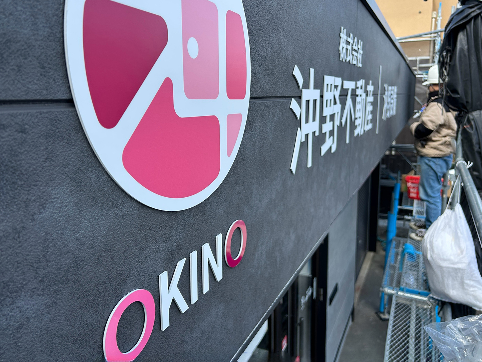 沖野不動産のファサードサインの施工中の写真です。