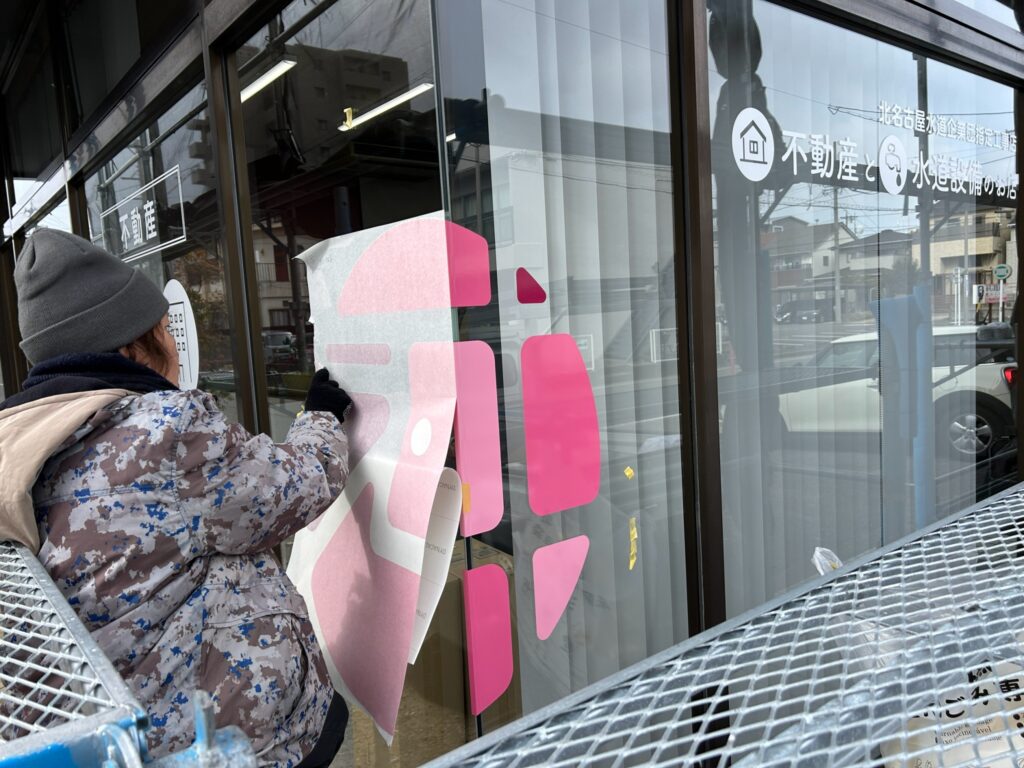 沖野不動産のガラスサインの施工中の写真です。