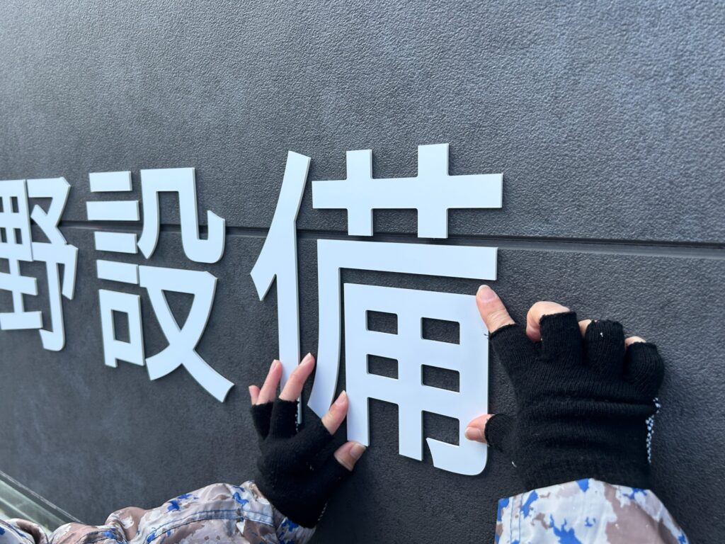沖野不動産のファサードサインの施工中の写真です。
