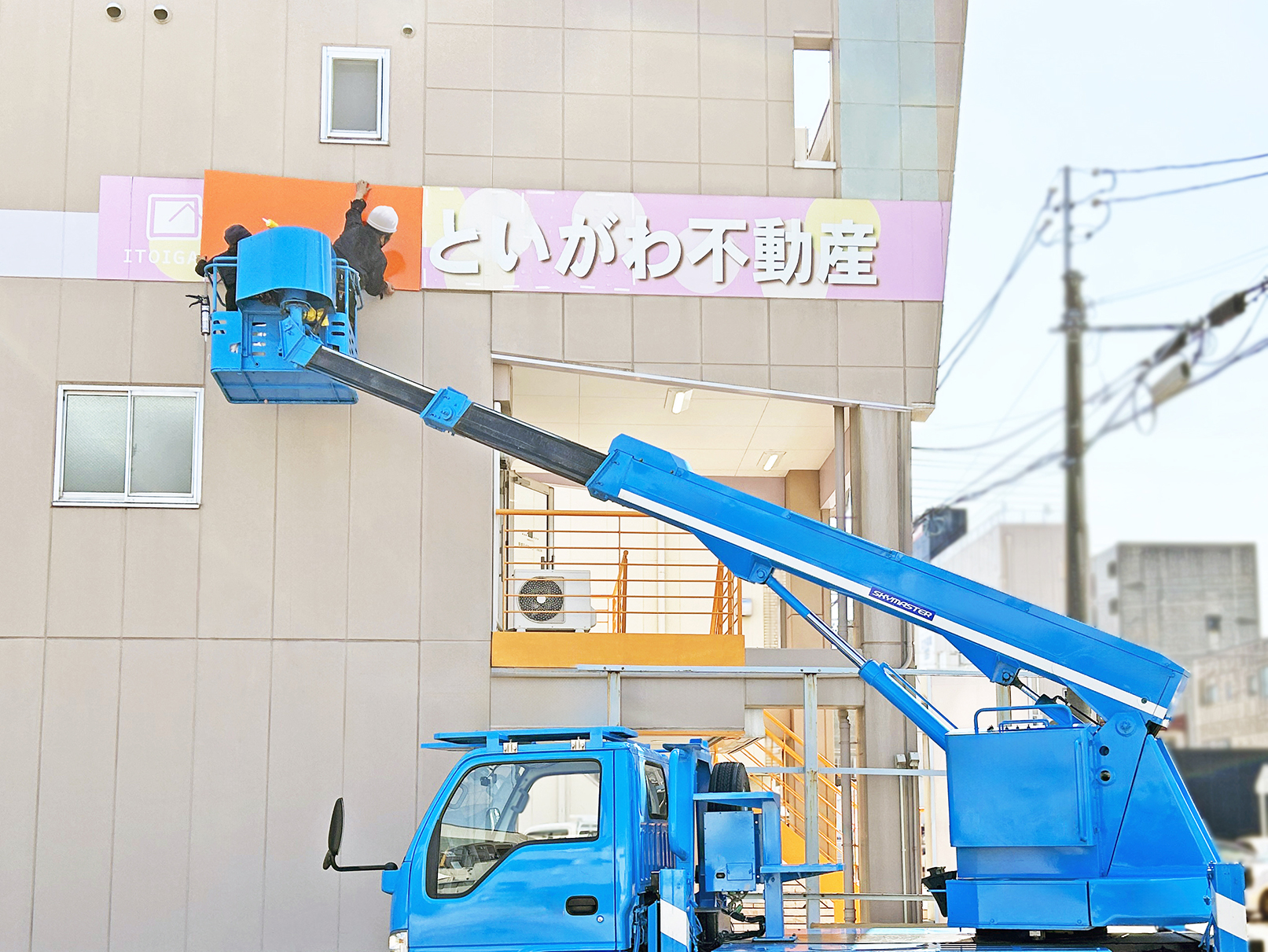 愛知県稲沢市の「いといがわ不動産」様の壁面看板の施工中写真です。