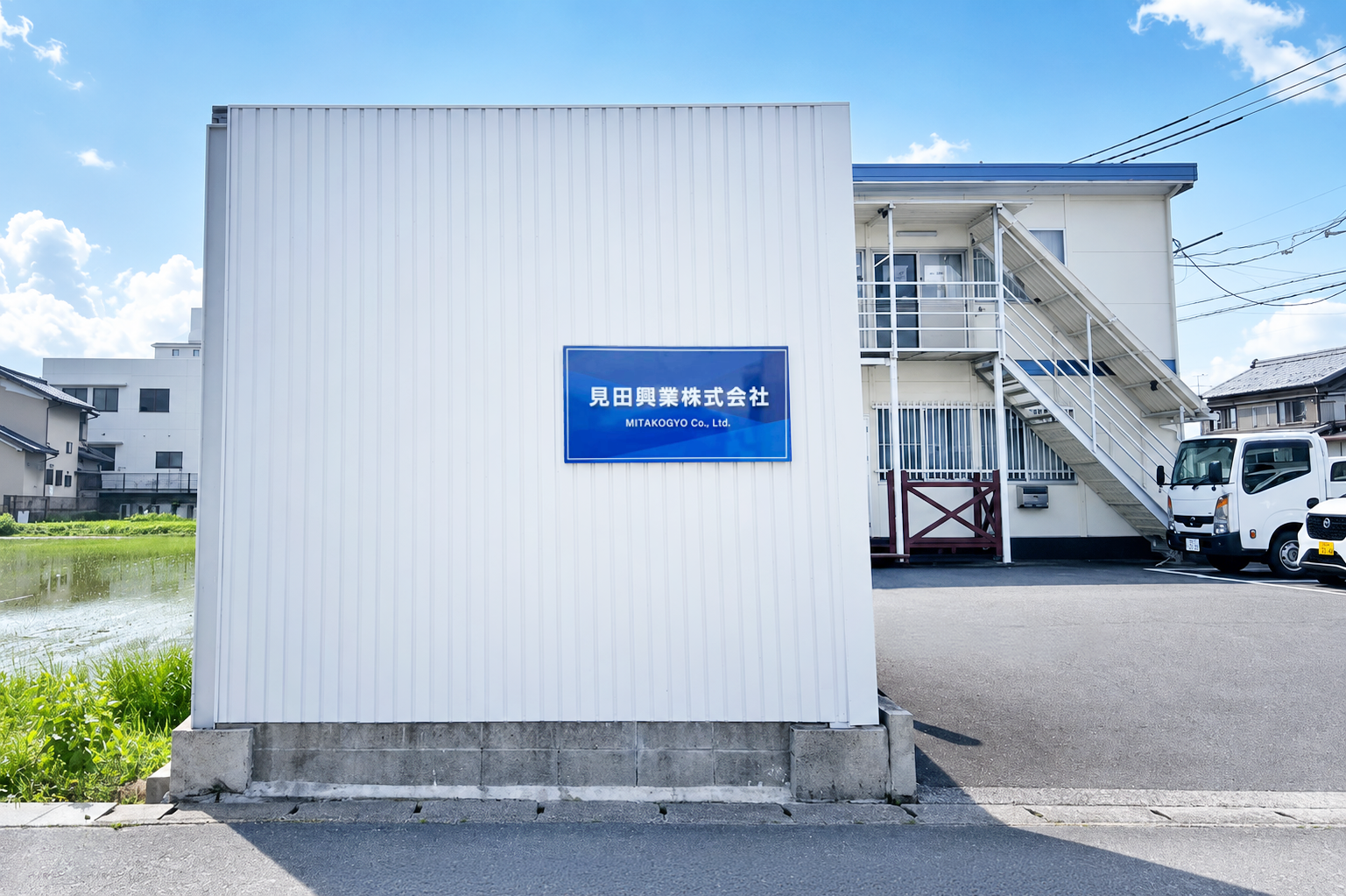 見田興業株式会社の社屋の表札看板と建物の写真です